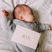 neutraal geboortekaartje voor een jongen of meisje met de naam in goudfolie en een linnen achtergrond